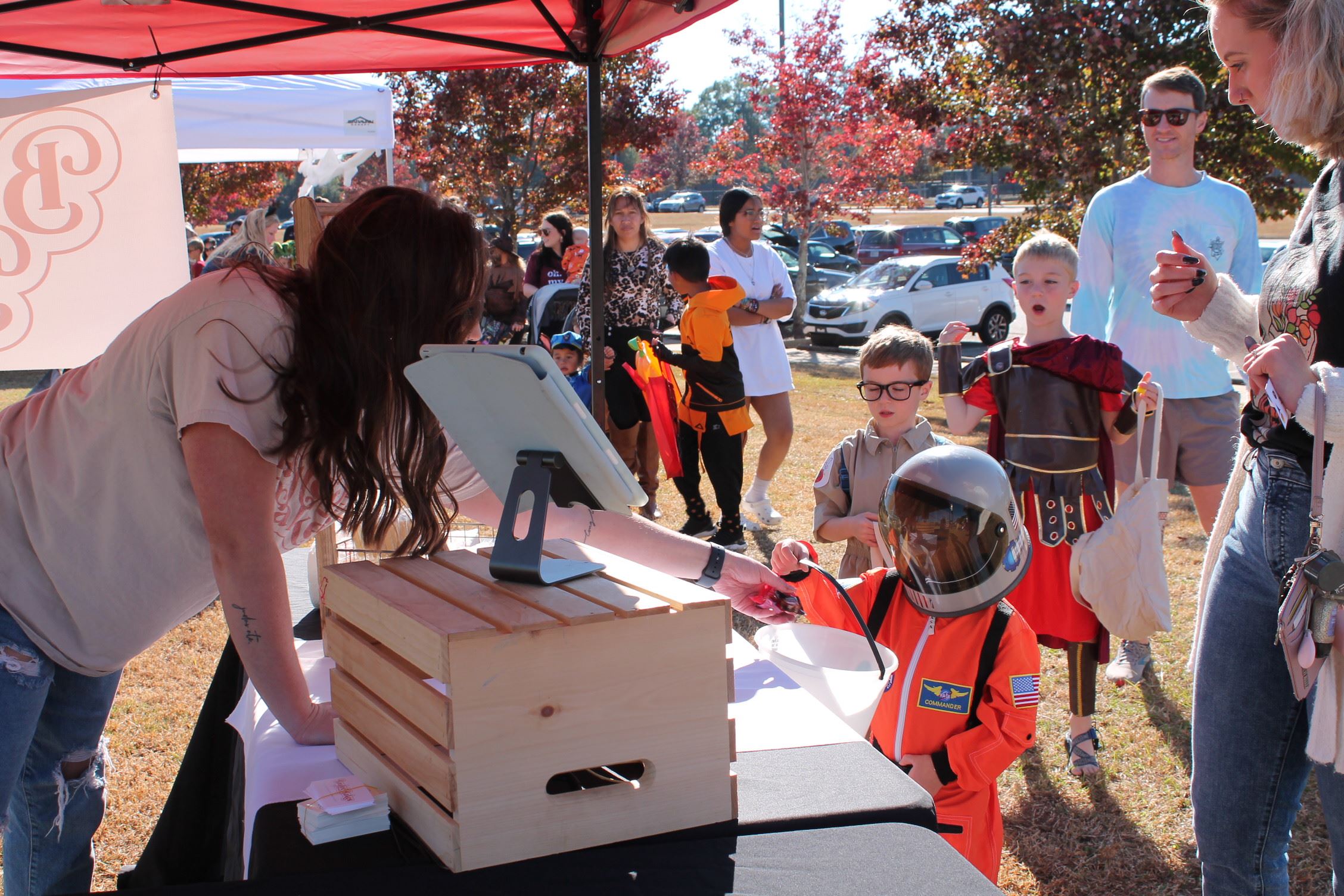 child dressed as astronaut being given cookie at Trick or Treat Trail