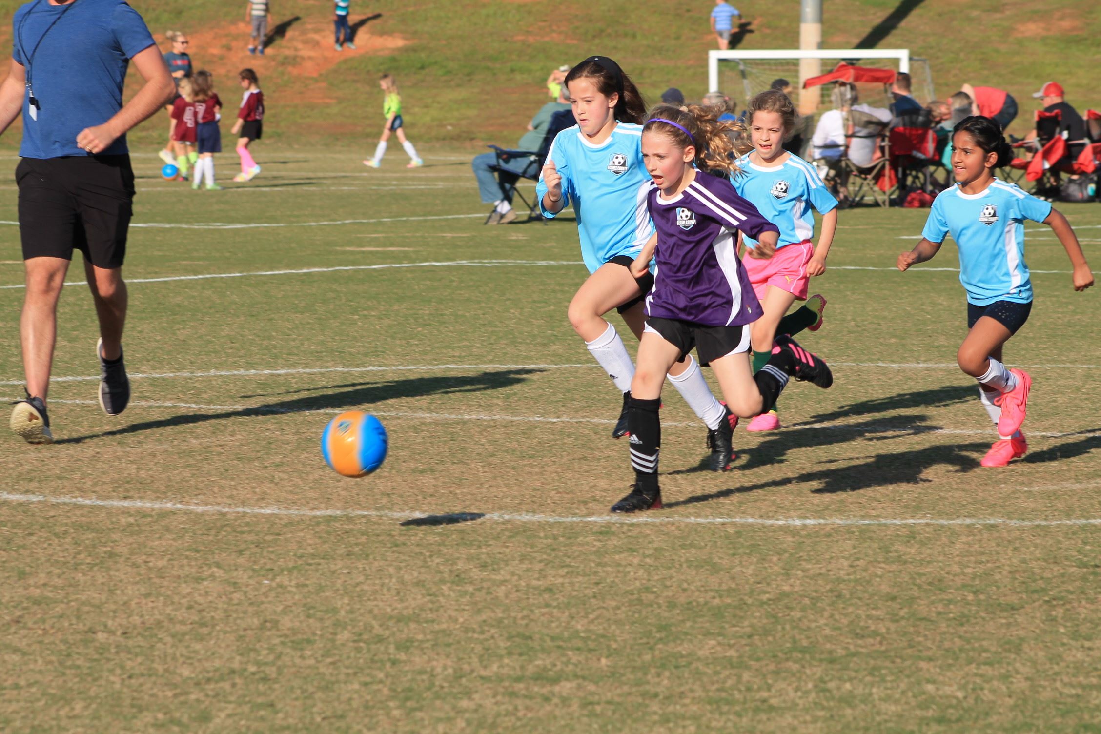 girls playing soccer on the field 