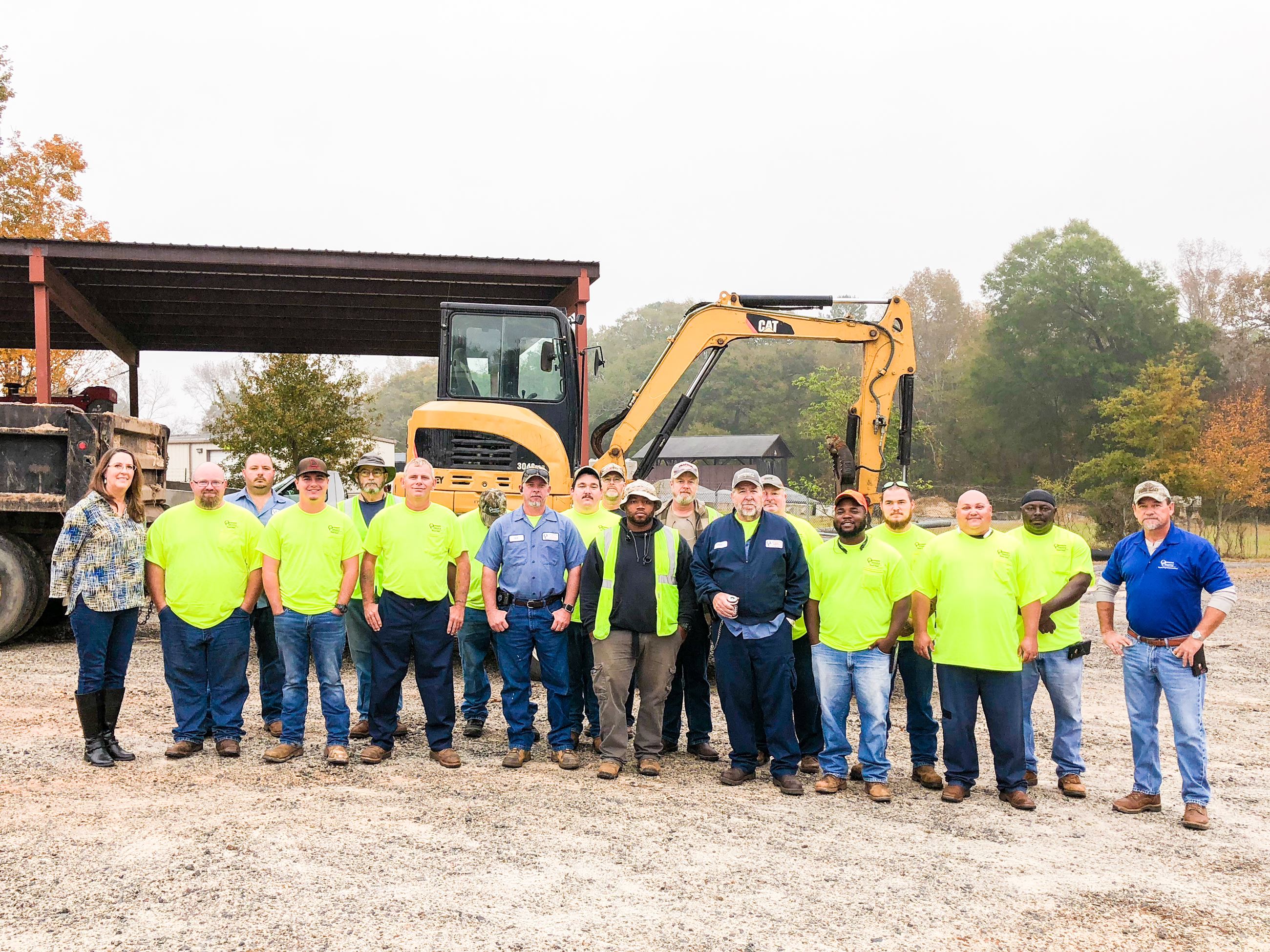 Photo of Road Department Staff Standing in Front of Road Equipment
