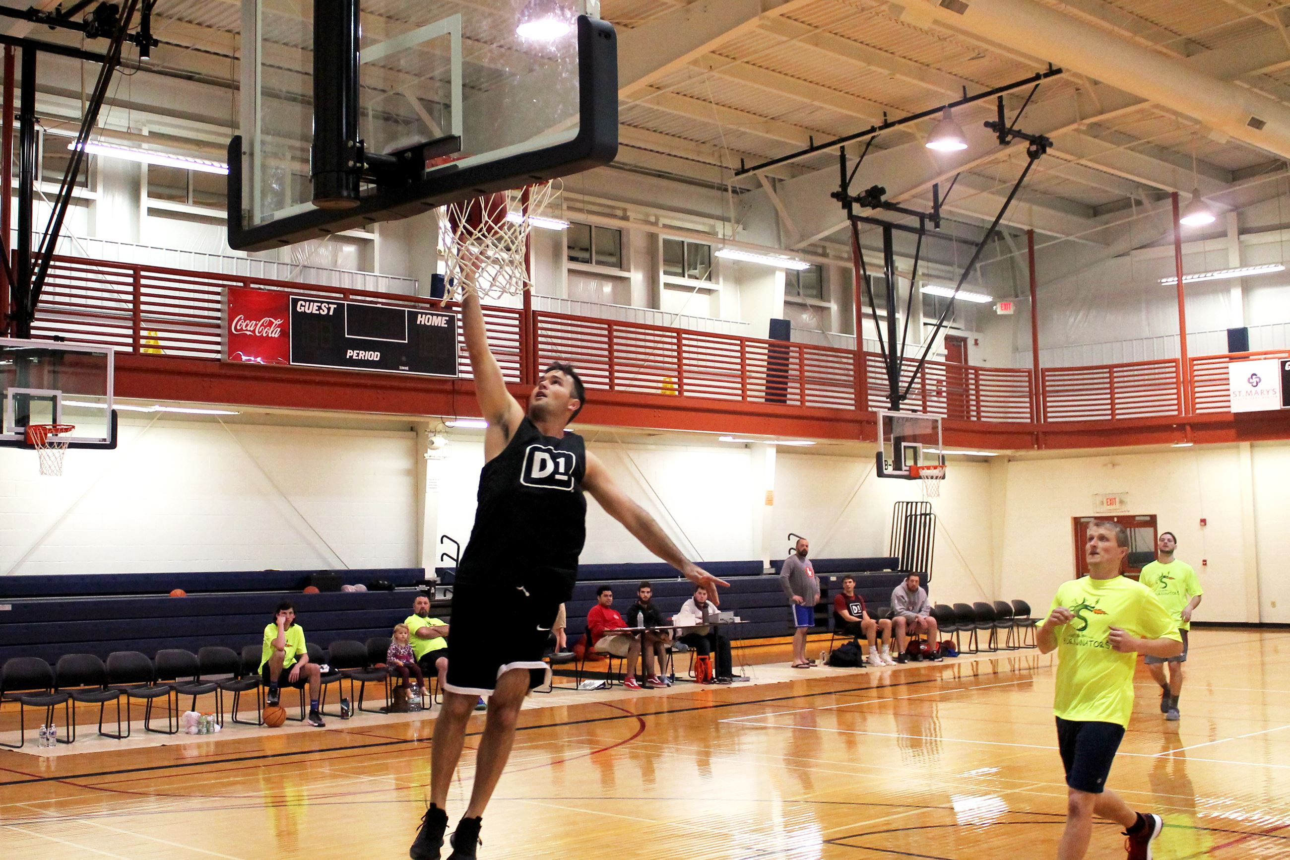 Adult male basketball player completing lay up